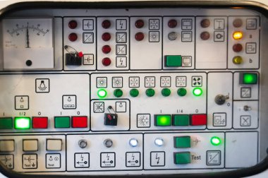 Aydınlatılmış göstergeleri ve renkli düğmeleri olan endüstriyel kontrol paneli, gece vardiyası mühendisi tarafından kullanılan santral konsolunun kapatılması