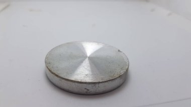 Beyaz arka planda metalik bir borunun yakın plan çekimi.