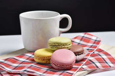 Macaron siyah arka plan üzerine kahve fincanı ile.