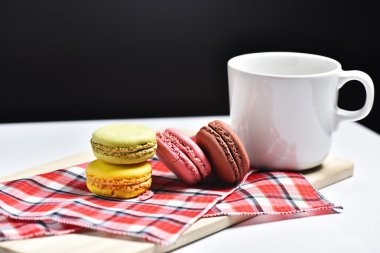 Macaron siyah arka plan üzerine kahve fincanı ile.