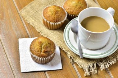 Ahşap masa kahve ile muz fincan kek.