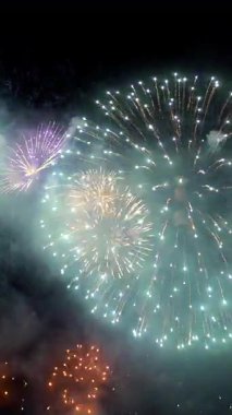 Parlak ve canlı havai fişekler şehrin üzerindeki gece gökyüzünü aydınlatıyor, yerel kutlamalar sırasında çeşitli renkler ve desenler sergiliyor. Seyirciler hayret verici görüntüden büyülendiler..