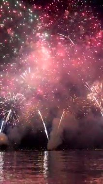 Görkemli bir havai fişek gösterisi gölün üzerindeki gece gökyüzünü aydınlatıyor ve suda çarpıcı renkler ve yansımalar yaratıyor. Kalabalık gösterinin tadını çıkarırken heyecan havayı dolduruyor..