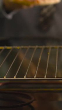 Resmi kıyafetli bir işadamı işten sonra hızlı bir akşam yemeği hazırlar ve dondurulmuş pizzayı fırına koyar. Yoğun yaşam tarzı, kolaylık ve evde fast food kavramı.