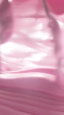 Karıştırıcıyla pürüzsüz pembe krema çırpma yakın çekim. Yumuşak, kabarık doku ve parlak yüzey tatlı hazırlama, pasta dekorasyonu veya güzellik ürünü arka planı için mükemmeldir..