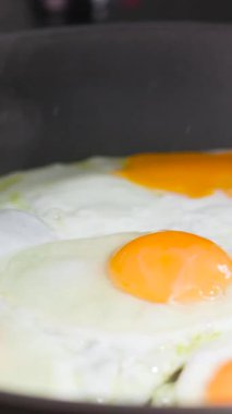 Tavada güneşte pişmiş yumurta pişirmek zengin sarıları ve kabarık beyazı gösterir ve lezzetli bir kahvaltı seçeneği sunar. Mükemmel altın ve eğlenmeye hazır.