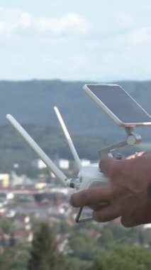 Bir insan, şehrin ufuk çizgisinin çarpıcı hava görüntülerini yakalamak için bir insansız hava aracı hazırlıyor. Yerleşim uzaktaki dağları içeriyor, güzel manzarayı güzelleştiriyor..