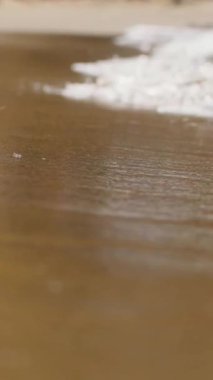 Güneş batarken, yumuşak dalgalar ahşap bir yüzeye çarpar ve sakin ve huzurlu bir atmosfer yaratır. Gökyüzünün renkleri güzel bir şekilde suya yansıyor..