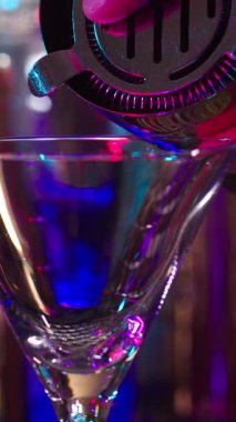 Bir barmen renkli ışıklarla dolu canlı bir ortamda ustaca kokteyller hazırlar. Kadehler tokuşturur ve kahkahalar havayı doldurur..