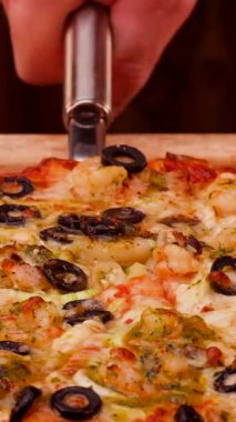 Taze pişmiş pizza bol zeytin ve karides sosuyla servis edilir. Sıcak, davetkar mutfak vitrinleri her durum için mükemmel bir yemektir..