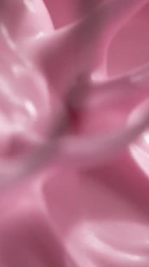 Makro yakın çekim, pürüzsüz pembe krem çırpıcıyla kaldırılıyor. Doku parlak ve ipeksi. Tatlı hazırlama, hamur işleri ve yemek için mükemmel bir görsel hareket yaratıyor.