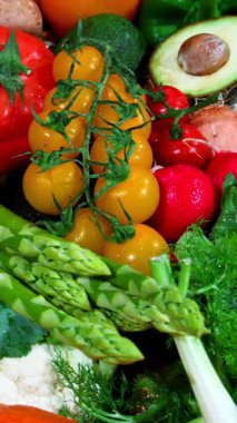 Parlak renkli domatesler, kuşkonmaz ve biberler çerçeveyi doldurarak yerel bahçelerden gelen etkileyici çeşitlilikte taze sebzeler sergiliyorlar. Bu renkli düzenleme sağlıklı beslenmeyi ön plana çıkarıyor..