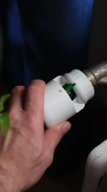 Bir el, bir ev ortamında su musluğunda sıcaklık kontrol vanası kullanırken görülüyor. Gündelik görevler için doğru su sıcaklığına ulaşılması üzerinde duruluyor.