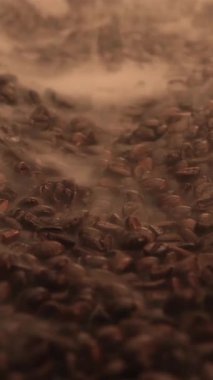 Coffee beans are slowly roasted in a traditional workshop. The rich aroma fills the air as they turn darker, showcasing the art of coffee preparation.