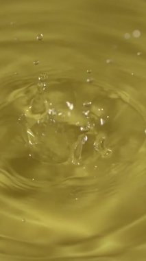 Tek bir damlacık suyun sakin bir bedenine düşer ve dairesel bir dalgalanma etkisi yaratır. Güneş ışığı yüzeyden yansıyarak, dışarıdaki huzur ortamını güçlendirir..