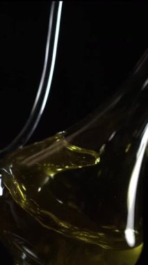 Yakından bakınca zeytinyağının cam bir kaba döküldüğünü görüyoruz. Altın sıvının pürüzsüz bir dokusu vardır ve ışığı yansıtarak rengini belirtir..