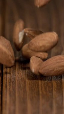 Bademler bir konteynırdan ahşap bir masaya dökülüyor. Bademler ahşap ile temas kurduklarında tüm yüzeye yayılıyorlar. Bu evde yemek pişirmenin bir kısmını gösteriyor..