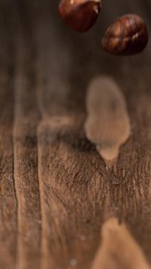 Bir fındık ahşap bir yüzeye düşer ve nazikçe zıplar. Kamera, fındık oturdukça ahşap tahılın detaylarını vurgular. İki nesne arasındaki etkileşimi yakaladığımız an.