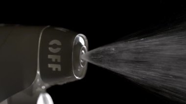 Yakından bakınca, sprey hortumunun bir sis saldığını görüyoruz. Bu eylem, böcek ısırıklarını önlemek için yapılan bir rutinin bir parçası olarak meydana gelir..