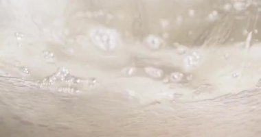 Şekerin bir karıştırma kabının içinde kırbaçlandığı görüntüyü kapat. Hızlı hareket köpük ve kıvrımlı doku oluşturur. Karışım hafif ve havadar olur. Çekimler pişirme hazırlığını temsil ediyor