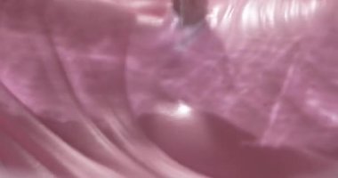 İçindekiler, çırpıcının pembe kremayı karıştırması gibi bir kasede birleşir. İşlem bir mutfakta gerçekleşiyor. Bu etkinlik bir pişirme projesinin hazırlıklarını gösterir.