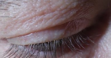 Aşırı yakın çekim, göz kapağının detaylarını gösterir. Cilt dokusunu ve kirpiklerini renklendirir. Doğal ışık göz bölgesinin görüntüsünü güçlendirir..