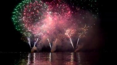 Gölün üstündeki gece gökyüzünde renkli havai fişekler patladı. İnsanlar yaz akşamları aydınlık gösterileri izlemek için kıyı boyunca toplanırlar..