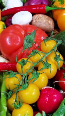 İlkbaharda yerel bir pazarda taze sebze koleksiyonu sergilenir. Parlak domatesler, biberler ve diğer ürünler satışta. Alıcılar ögeleri keşfeder ve seçer.