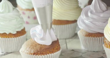 Tatlılar renkli kremalarla süslenir. Kekler üzerinde farklı şekiller yaratmak için bir boru torbası kullanılır. Samimi bir mutfak ortamında geçiyor..