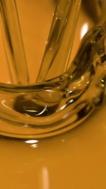 Süper Yavaş Çekim Altın Zeytinyağı Yüzeyden aşağı akıyor, Sıvı Akımın Kapalı Makroskobu Parıltılı Akıntı Oluşturuyor