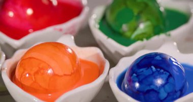 İnsanlar resim yapmaya hazırlanırken parlak renkler küçük kaseleri dolduruyor. Sahne, şahısların sanat yoluyla yaratıcılıklarını keşfettikleri bir atölye..