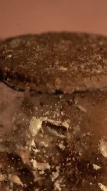 Kakao tozunun içinden yükselen çikolatalı kurabiye, kırıntılarla yükselen kurabiyelerin yavaş çekim makrosu.