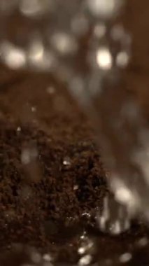 Kahve telvesinde su damlacıkları, yavaş su sıçramaları parlak ıslak doku oluşturur.