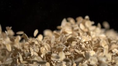 süper yavaş çekim uçan yulaf taneleri siyah arkaplanda, sinematik yavaş çekim yulaf ezmesinin makro görüntüsü