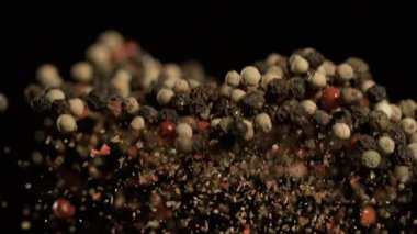 Siyah arka planda süper yavaş çekim biberleri yukarı doğru fırladı. Kırmızı siyahın yüksek hız görüntüsü.