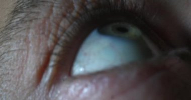 Göz kapağı, göz bebeği ve göz bebeği gibi ayrıntıları gösterir. Parlak ışık dokuları ve renkleri vurgular. Bu çekim, insan anatomisine benzersiz bir bakış açısı yakalıyor..