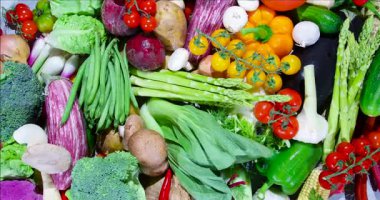 Bir masanın üzerinde çeşitli taze sebzeler düzenlenir. Renkli sergide sebzeler, sebzeler ve domatesler yer alıyor. İnsanlar canlı seçenekleri keşfediyor olabilir..