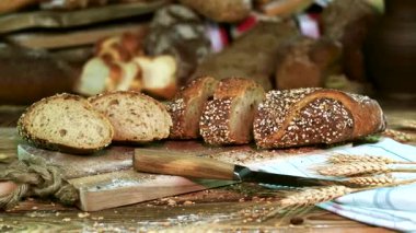 Dilimlenmiş ekmek yakınlardaki tahıllı bir masanın üzerinde duruyor. Sahnede daha fazla somun ve ev yapımı pişirme sahnesinin sergilendiği kırsal bir ortam yer alıyor..