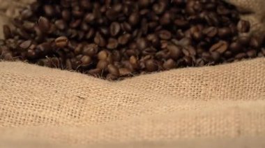 Süper yavaş çekim kahve çekirdeklerini çuvala koymak, canlı zıplamak, ritmik takla atmak, yakın tahıl detayı, jute