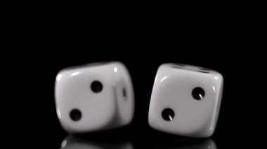 Süper Yavaş Hareket, iki beyaz zar eğik ve parlak siyah yüzey üzerinde dürtükleme, oyuncu hareket, ince yansımalar.,