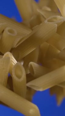 Super Slow Motion, Altın Penne Canlı Mavi Arkaplanda Yüzüyor, Arka Işıklı Makro Ürün Hareketi