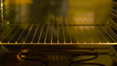 Pizzayı fırına, kabloya ve ısıtıcıya yerleştiren adam görünür hale geliyor, süpermarket peynirli dondurulmuş pizza pişiriyor.