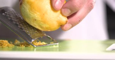 Kapanış Şefi Elleri Izgara Limon Zest, Parlak Sarı Kabuk Yeşil Tahtada Toplandı, Kontrollü Hareket, Güzel