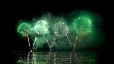 Gece Rıhtımı Havai fişekleri Yansıtıcı Su Üzerine Yeşil ve Kırmızı Patlamalar Dumanlı Gökyüzünü aydınlatıyor, Parıldıyor