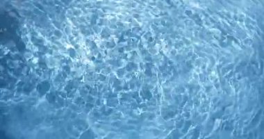 Işık, suyun yüzeyinde berrak bir havuzda dans eder. Güneş ışıl ışıl parlarken dalgaların ve yansımaların hareket ettiğini ve canlı bir atmosfer yarattığını görebilirsiniz.