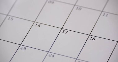 Takvim ayın günlerini gösteren bir ızgara düzenine odaklanır. 17. gün işaretlenirken, diğer günler görünür ama vurgulanmaz. Bu sahne planlama ve organizasyonu temsil ediyor..
