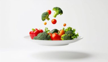 Üzerinde sanatsal olarak yüzen renkli taze sebzelerle dolu temiz beyaz bir tabak sağlıklı yeme ve tazeliği sembolize ediyor. Yemek, diyet ve sağlık kavramları için mükemmel..