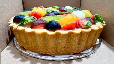 Karton kutuda meyveli tart. Renkli ve lezzetli tatlı seçenekleri. Fırın promosyonları, tatlı menüleri ve tatlıları için mükemmel.