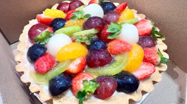 Karton kutuda meyveli tart. Renkli ve lezzetli tatlı seçenekleri. Fırın promosyonları, tatlı menüleri ve tatlıları için mükemmel.