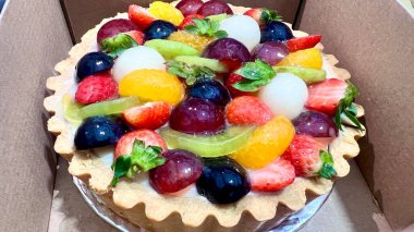 Karton kutuda meyveli tart. Renkli ve lezzetli tatlı seçenekleri. Fırın promosyonları, tatlı menüleri ve tatlıları için mükemmel.